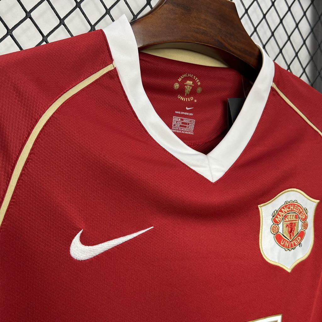 Red jersey with white-trim V-neck, Nike swoosh and Manchester United crest