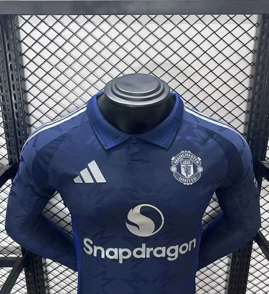 Dark blue Manchester United away jersey, close-up of collar, crest, and adidas logo