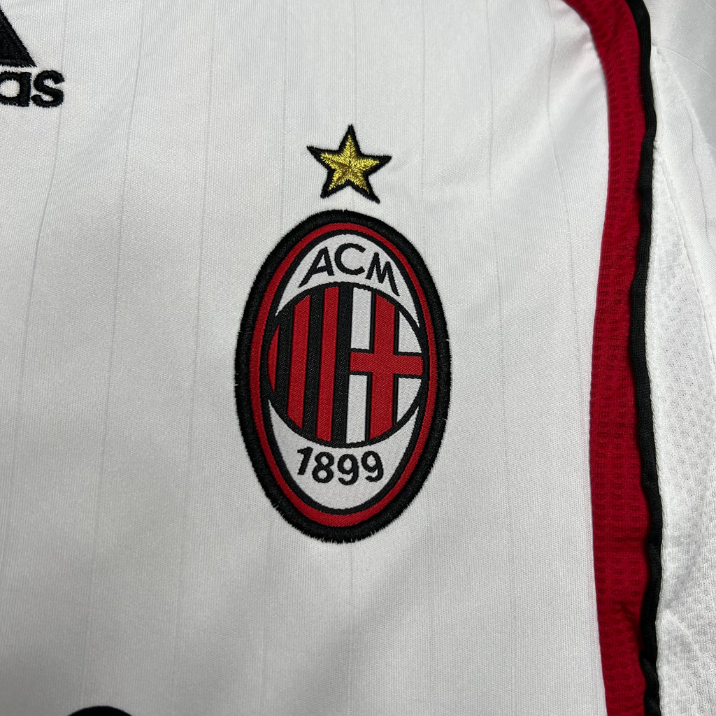 AC Milan crest patch with gold star on white jersey, red side trim