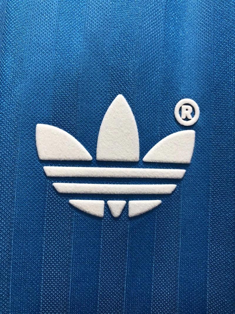 White adidas trefoil logo on blue textured retro soccer jersey chest