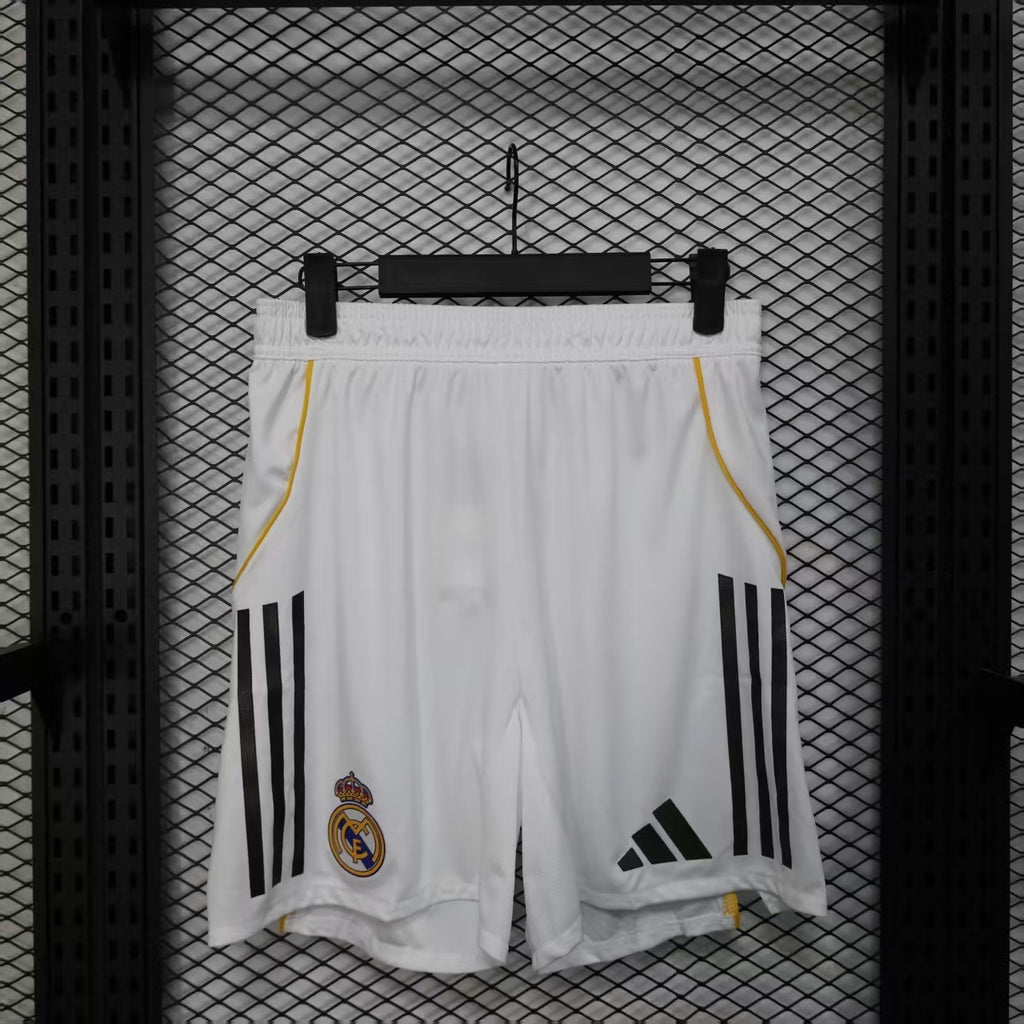 White soccer player shorts with yellow side piping and black triple stripe accents.
