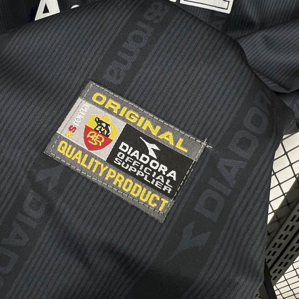 Retro football jersey label close-up, Diadora quality product patch on navy fabric