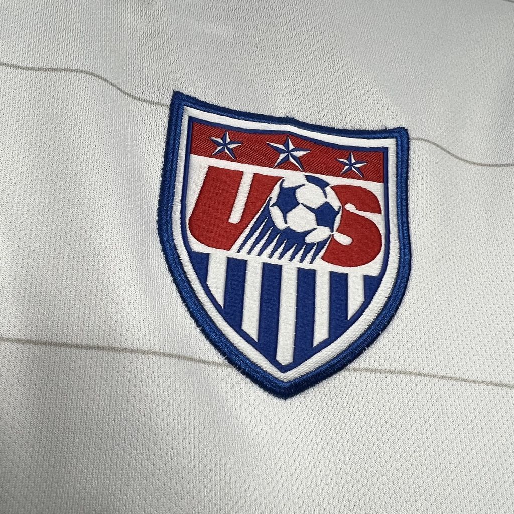 White soccer jersey with embroidered US crest badge with blue, red, and stars