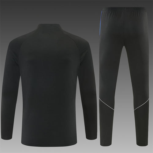 Black quarter-zip training top and jogger pants with blue accents and side stripe detailing