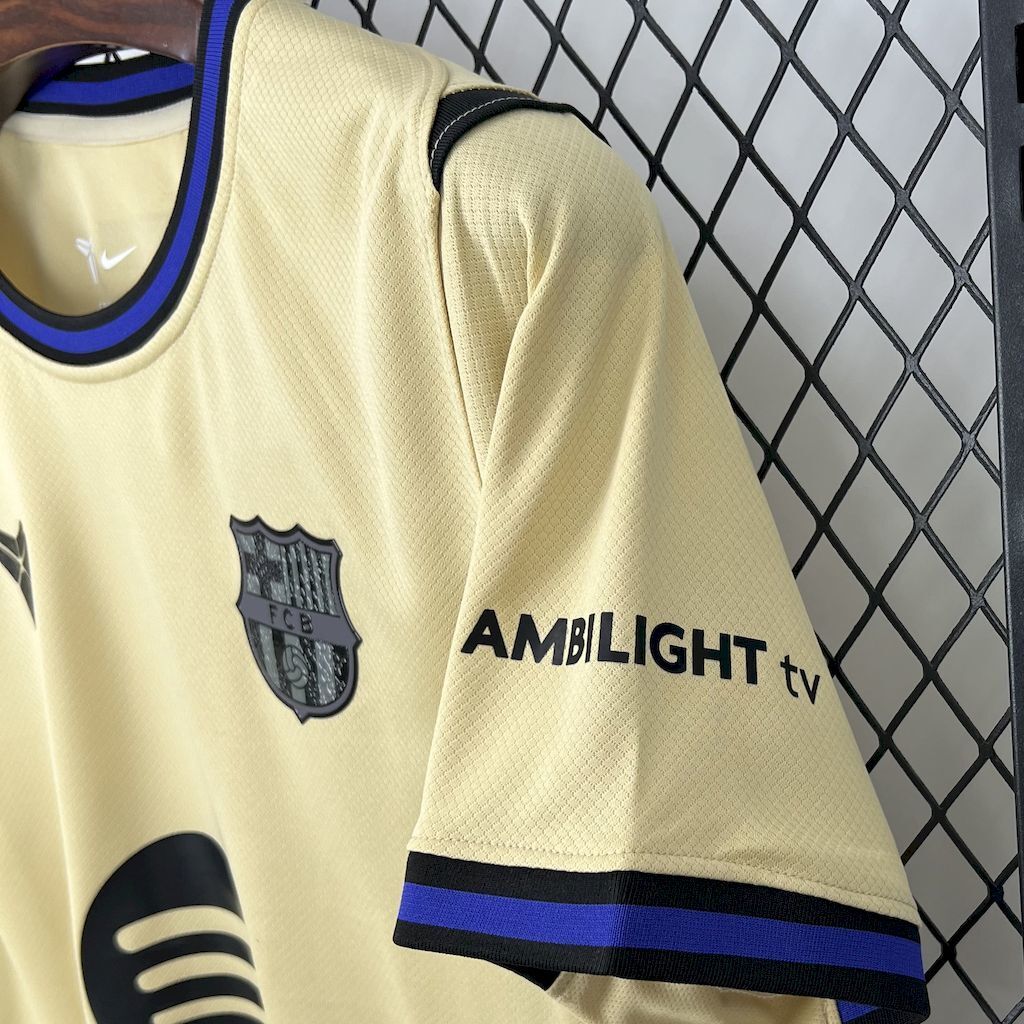 FC Barcelona jersey sleeve close-up, light yellow with FCB crest and AMBILIGHT tv