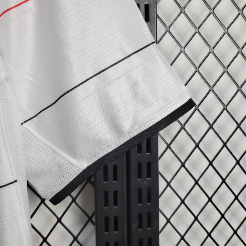 White football shirt sleeve and hem with black trim and red piping lines