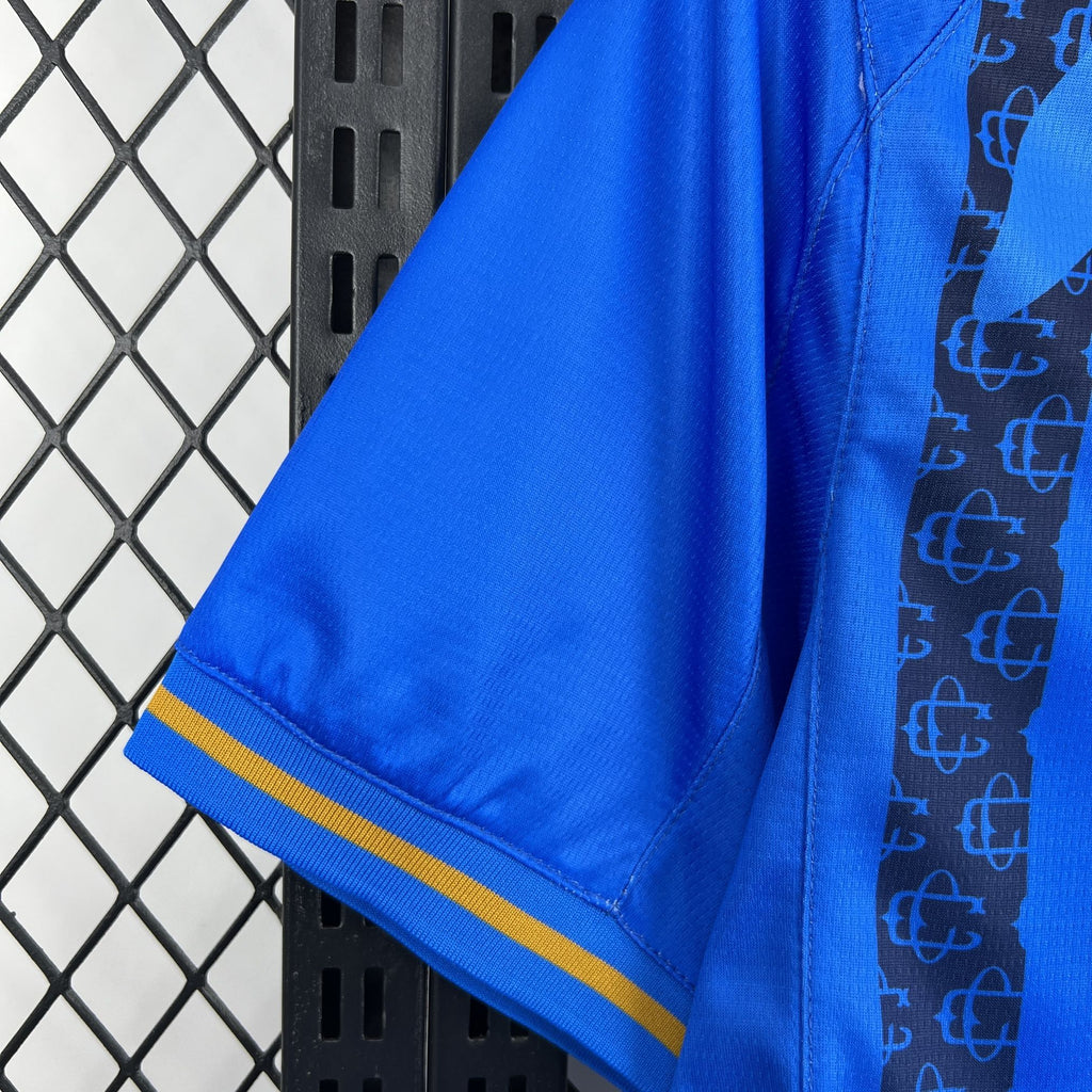 Blue soccer jersey sleeve hem with gold/yellow stripe trim and stitching