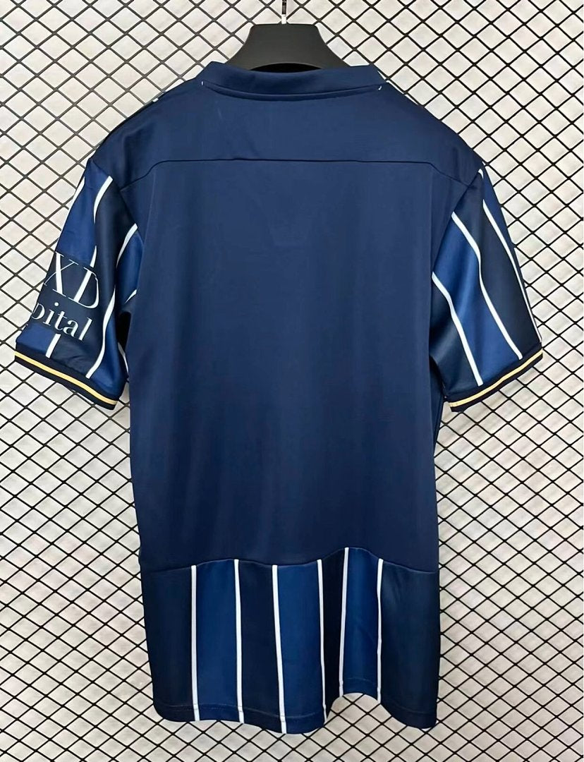 Navy football home shirt back view with white vertical stripes and short sleeves