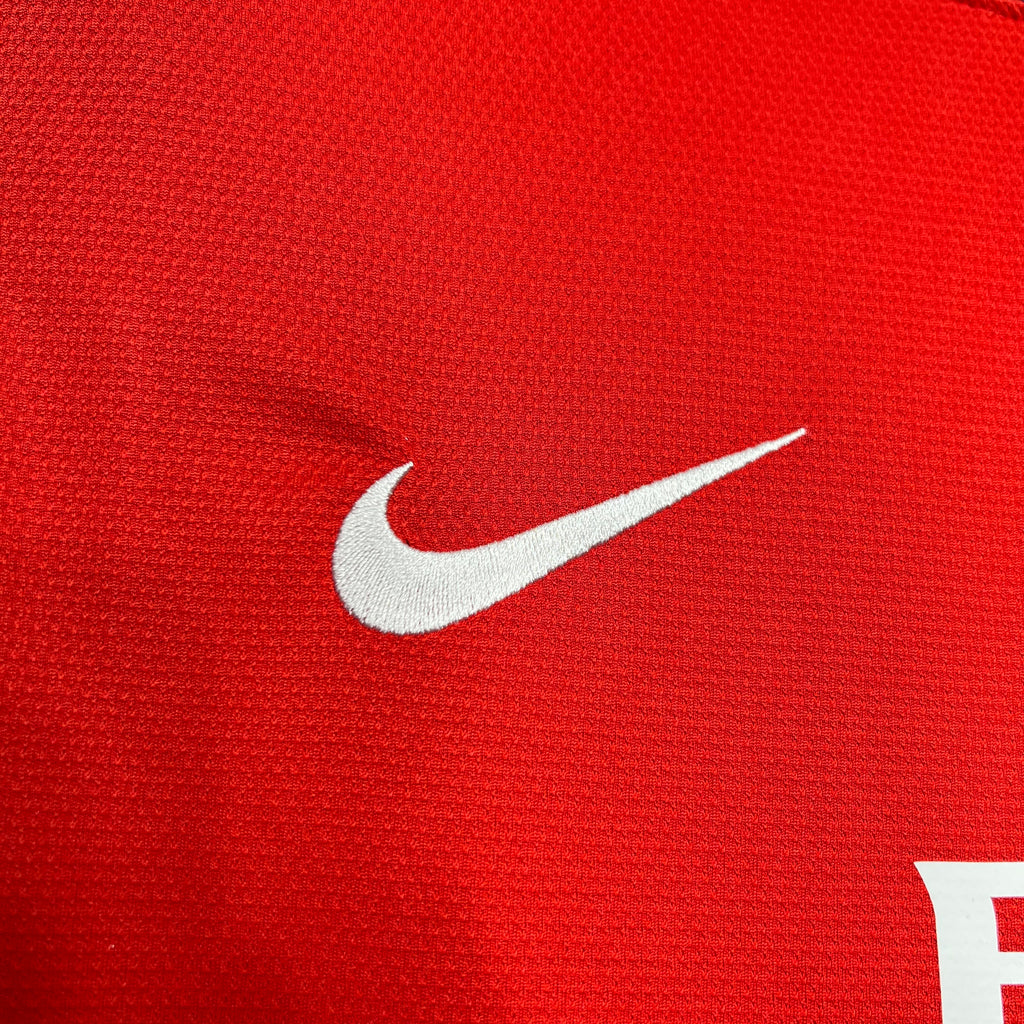 Red football jersey fabric close-up with white Nike swoosh