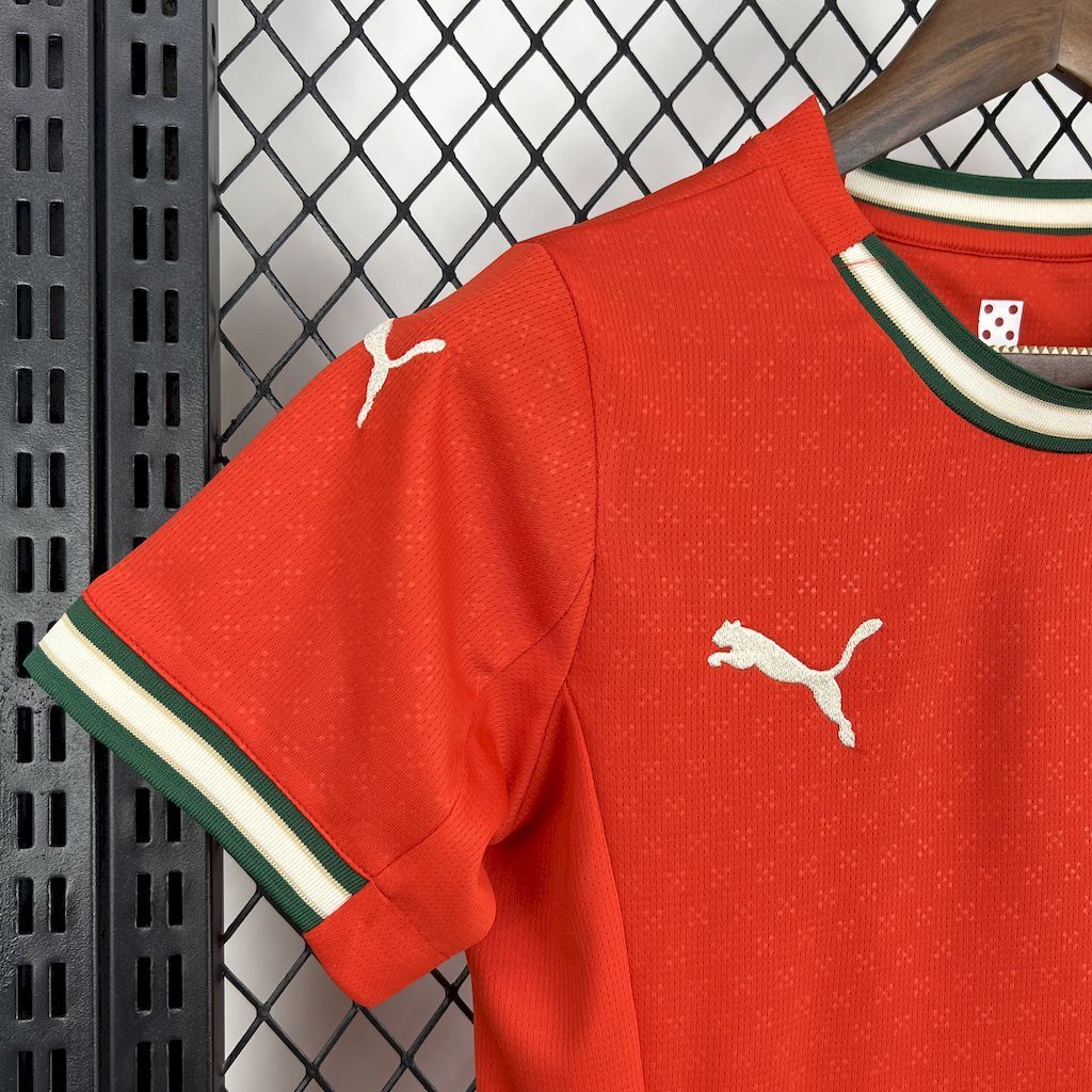 Women's red football jersey sleeve and chest with Puma logos and green trim