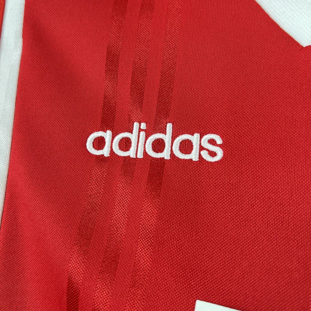 Adidas logo on red soccer jersey with vertical textured stripes