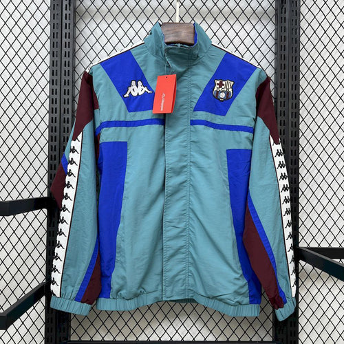 Light blue and royal blue windbreaker with front zipper and crest patch