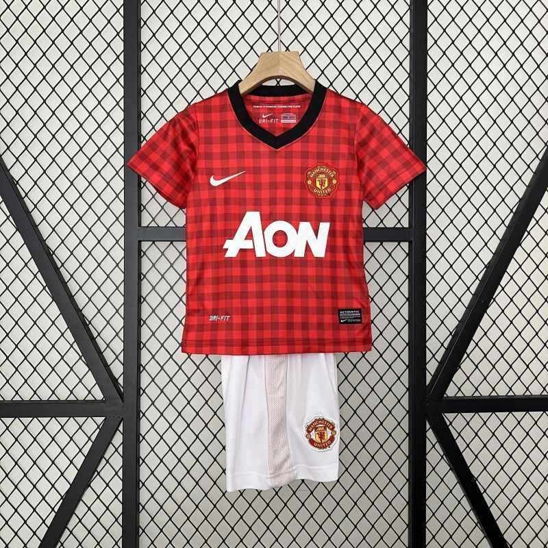 Kids Manchester United home kit: red plaid jersey with black trim and white crest shorts