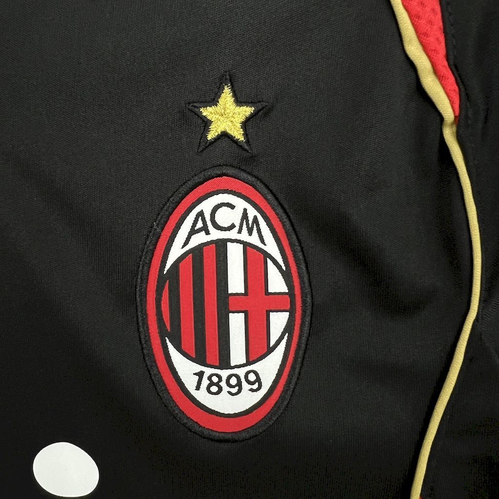 ACM crest patch on black jersey with small gold star and yellow-red edge trim