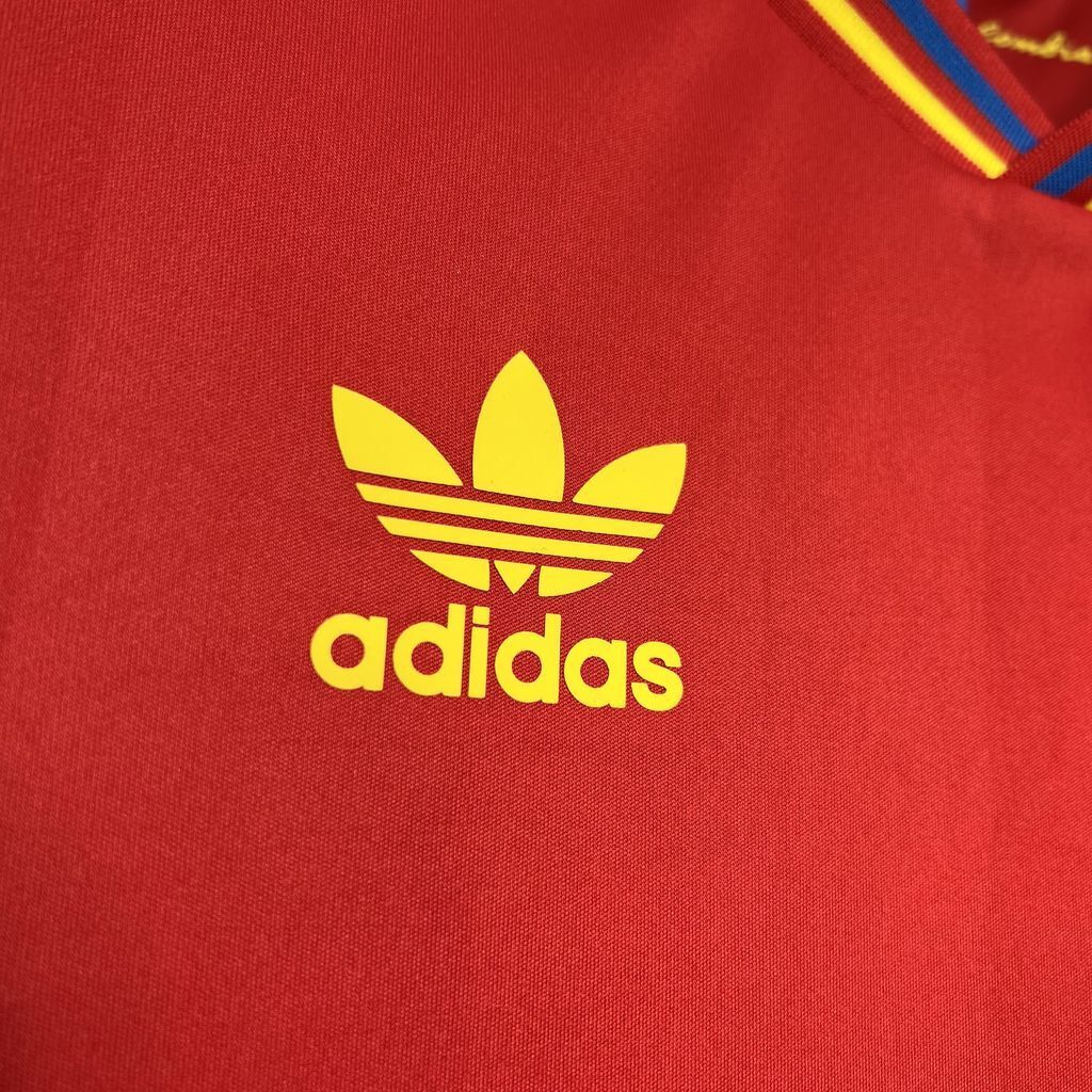 Yellow Adidas trefoil logo on red jersey