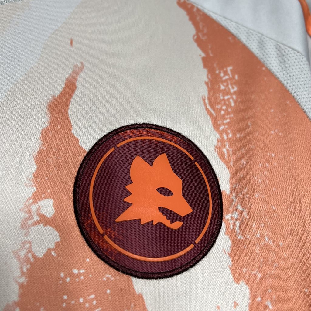 Orange and dark crest badge on white jersey fabric