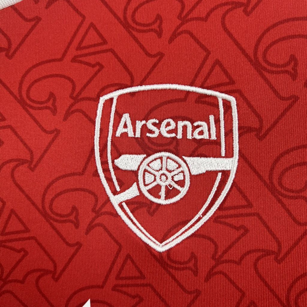 Red football shirt fabric with Arsenal crest emblem patch