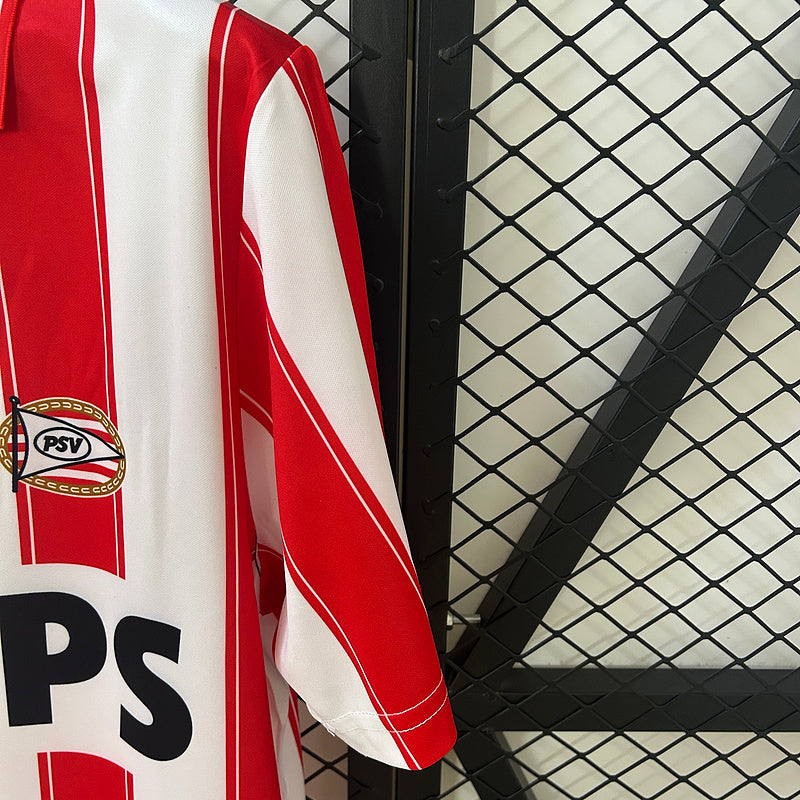 Red-and-white vertical striped soccer jersey sleeve with PSV crest patch