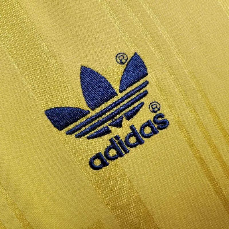 Yellow retro football jersey close-up of adidas trefoil logo in navy
