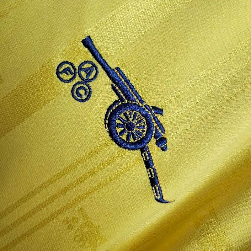 Yellow retro jersey fabric with navy circular emblem and crossed-bar detail