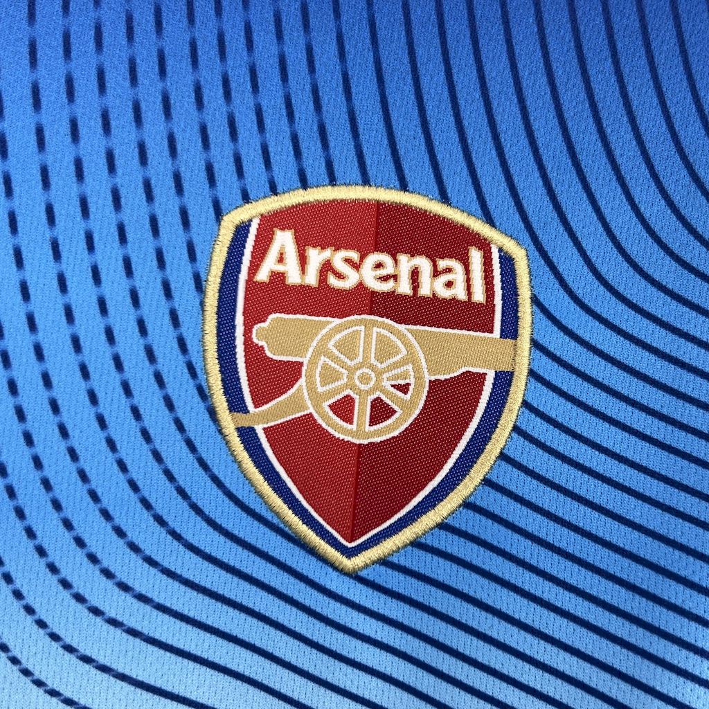 Arsenal shield crest on blue retro jersey with white and red detailing