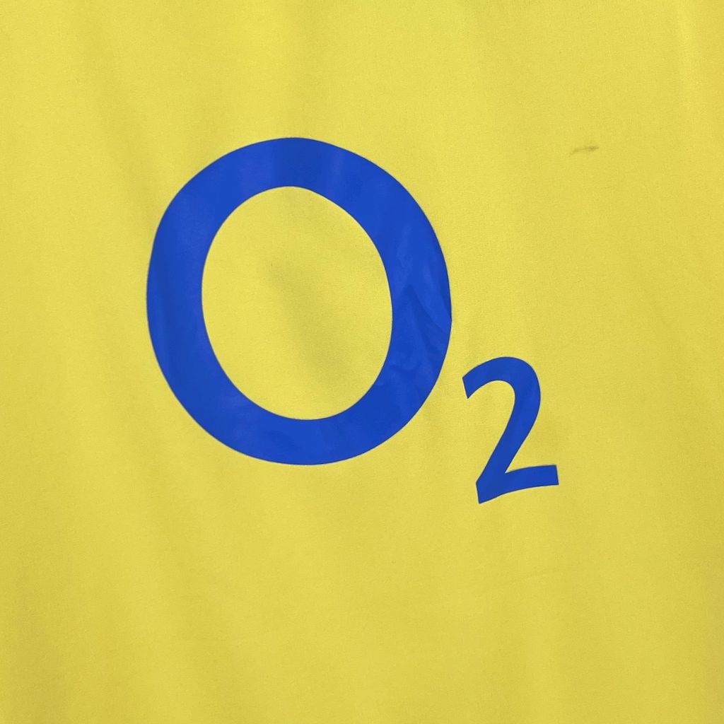 Close-up of yellow jersey fabric with large blue O2 sponsor number and text