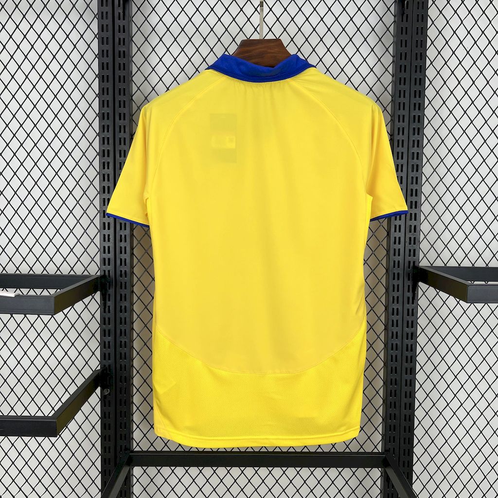 Back view of yellow retro football jersey with blue collar and partial sponsor text