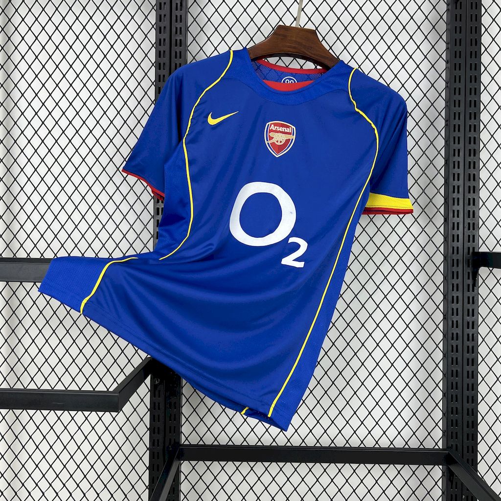 Blue football jersey with yellow piping, O2 sponsor, Arsenal crest, Nike swoosh