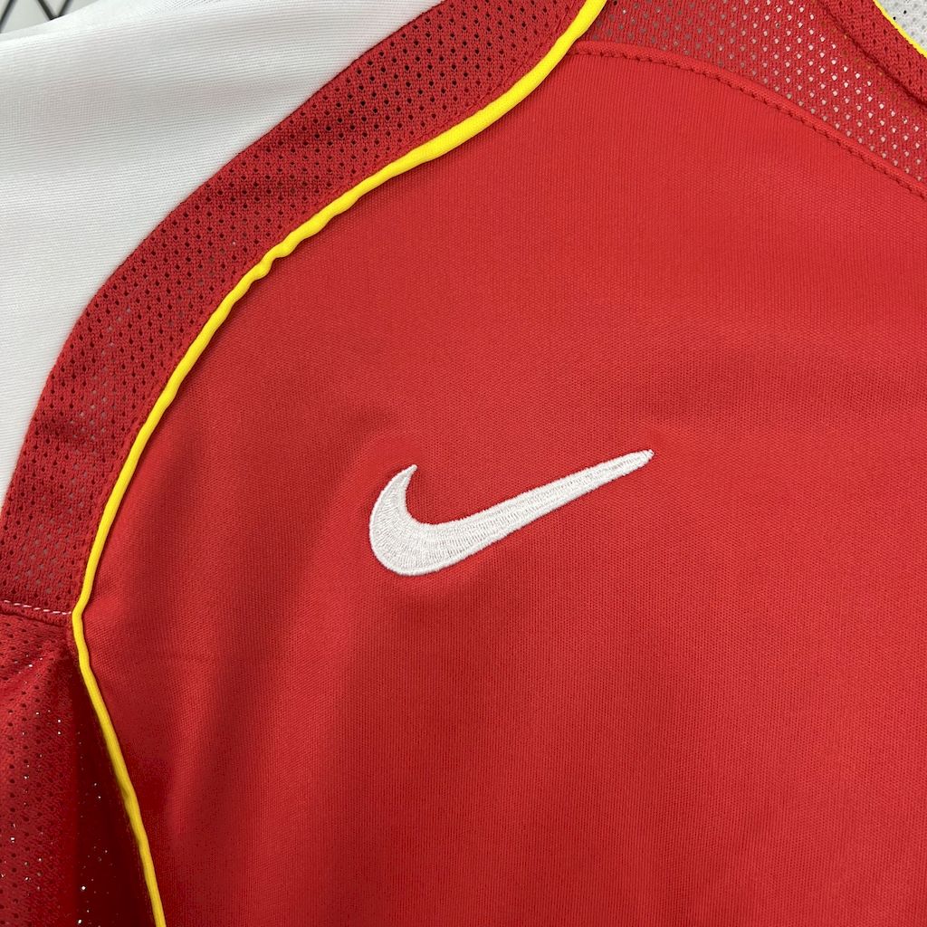 Red soccer jersey with white Nike swoosh on chest and yellow piping trim