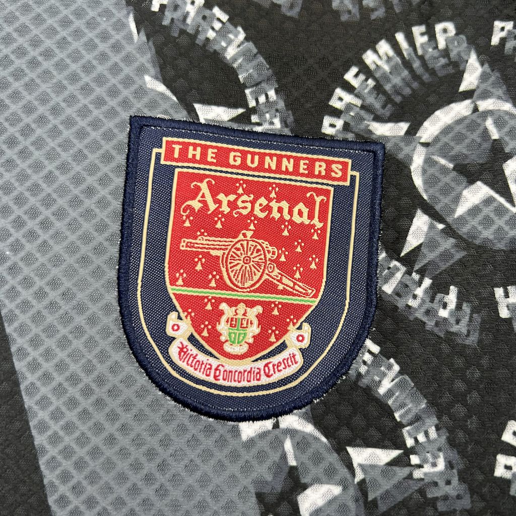 Arsenal crest patch on black goalkeeper jersey, blue border and red shield