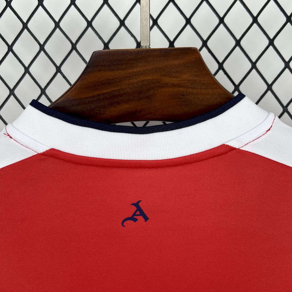 Red retro soccer jersey collar detail with white trim and small chest emblem