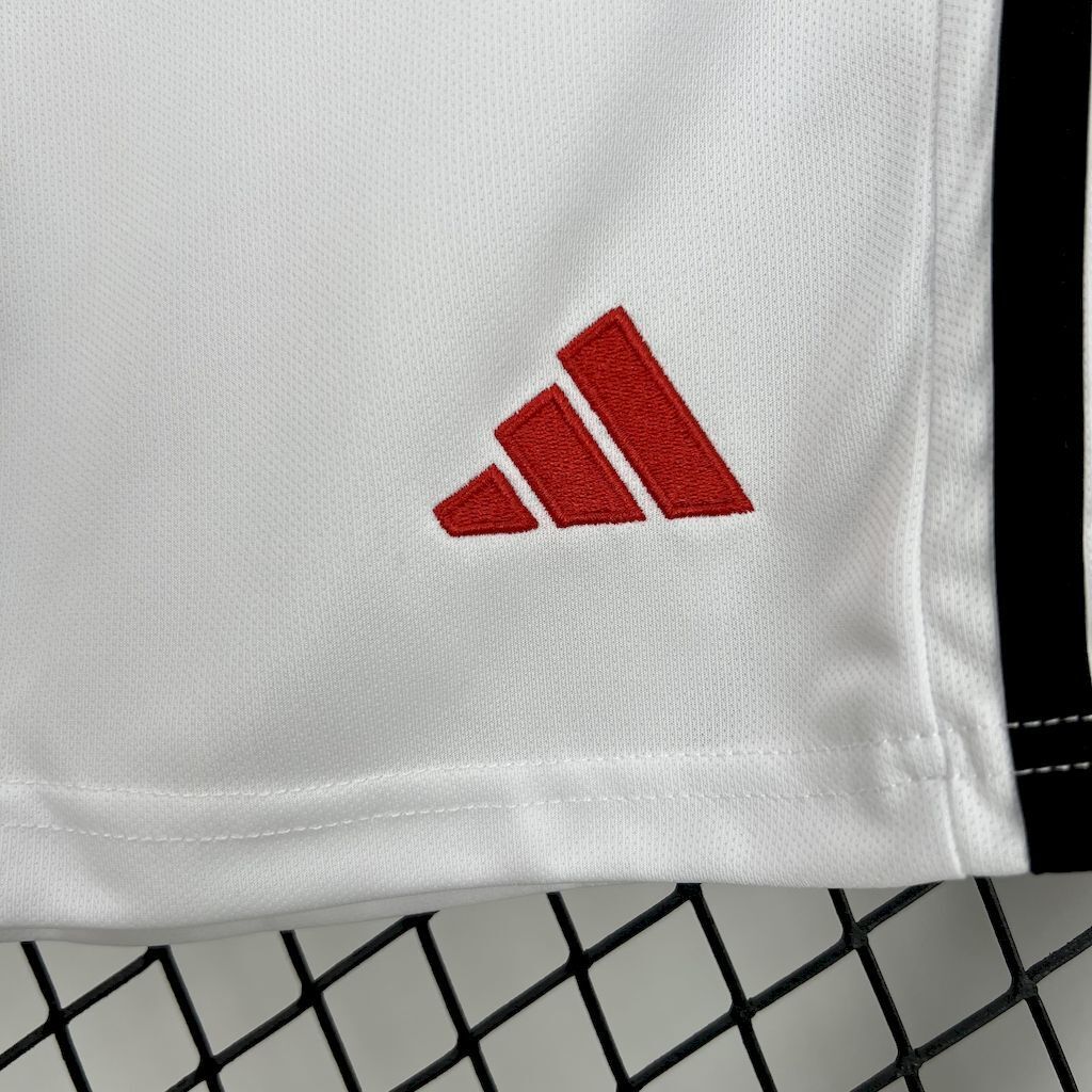 Kids white shorts close-up showing red adidas logo on fabric
