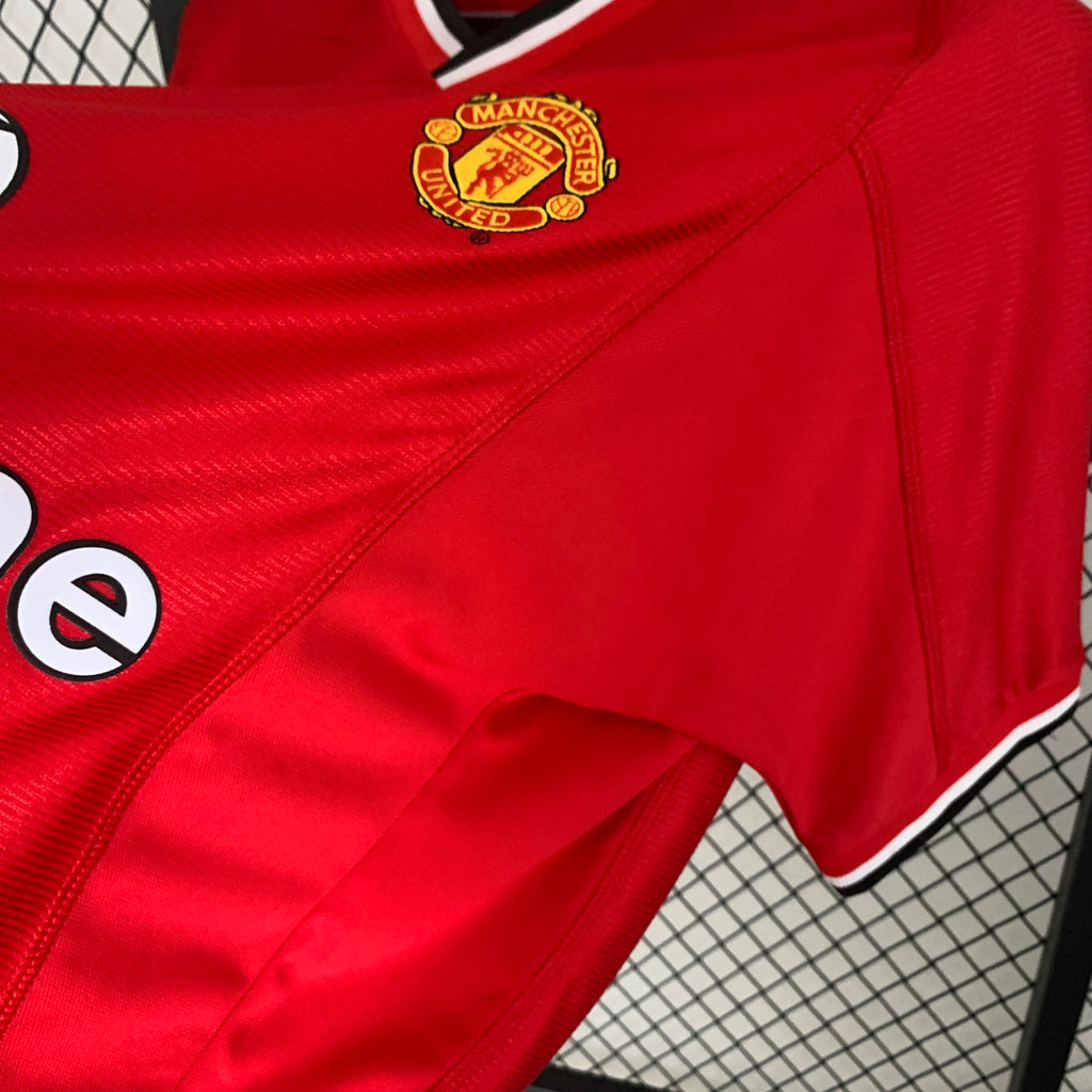 Red football shirt close-up: club crest and Vodafone sponsor on front