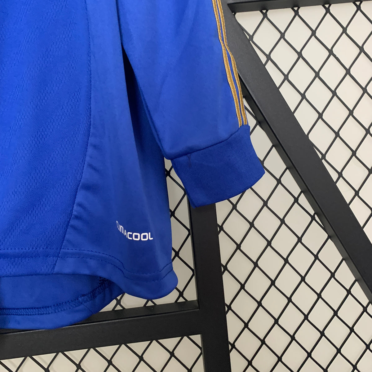 Blue long-sleeve soccer jersey sleeve with gold trim and Climacool logo