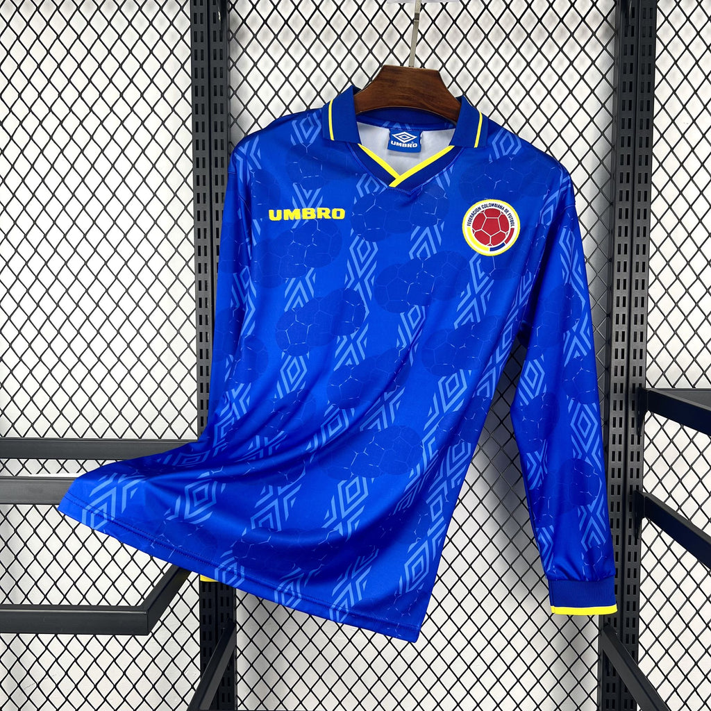 Blue long-sleeve away soccer jersey with geometric pattern, yellow-trim collar and cuffs