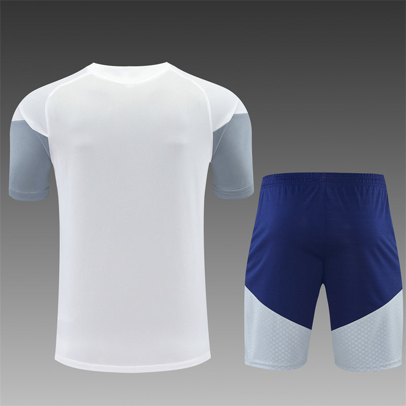 White training shirt with blue sleeves and navy shorts set with side panels