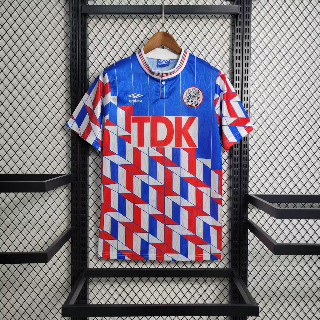 Blue retro away football jersey with red-and-white geometric pattern, TDK sponsor, crest