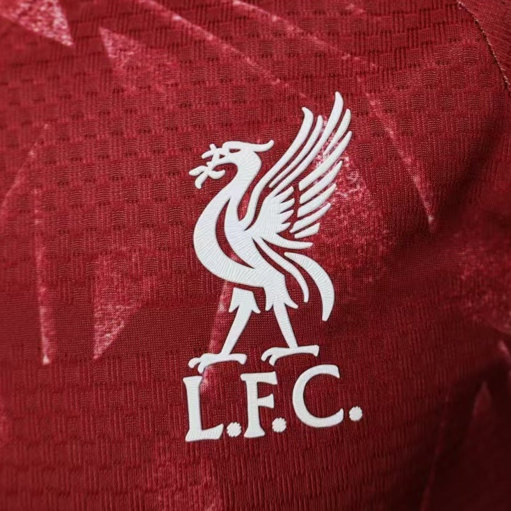 Red Liverpool FC home jersey close-up, white LFC crest on upper chest