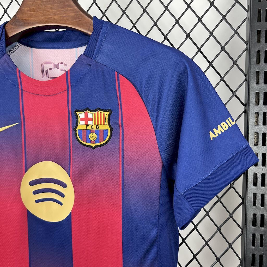 Kids FC Barcelona home jersey detail: blue sleeve with red-blue stripes and club crest