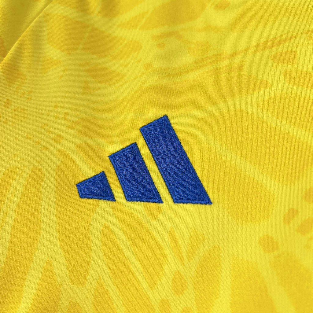 Yellow jersey with three blue adidas stripes logo on the chest.