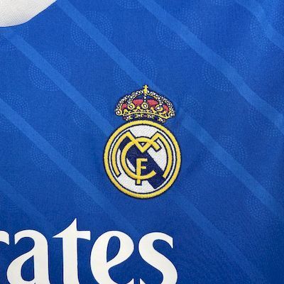 Blue Real Madrid jersey badge with Real crest on textured diagonal pattern