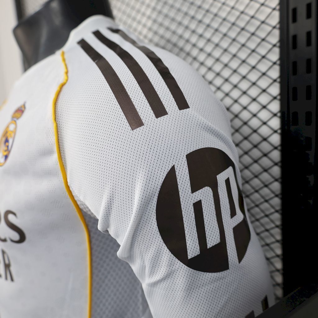 Real Madrid home jersey sleeve detail, white fabric with black adidas stripes