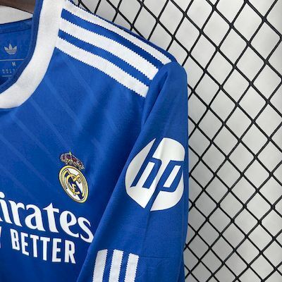 Jersey sleeve close-up with white stripes, BP logo, and Real crest on blue