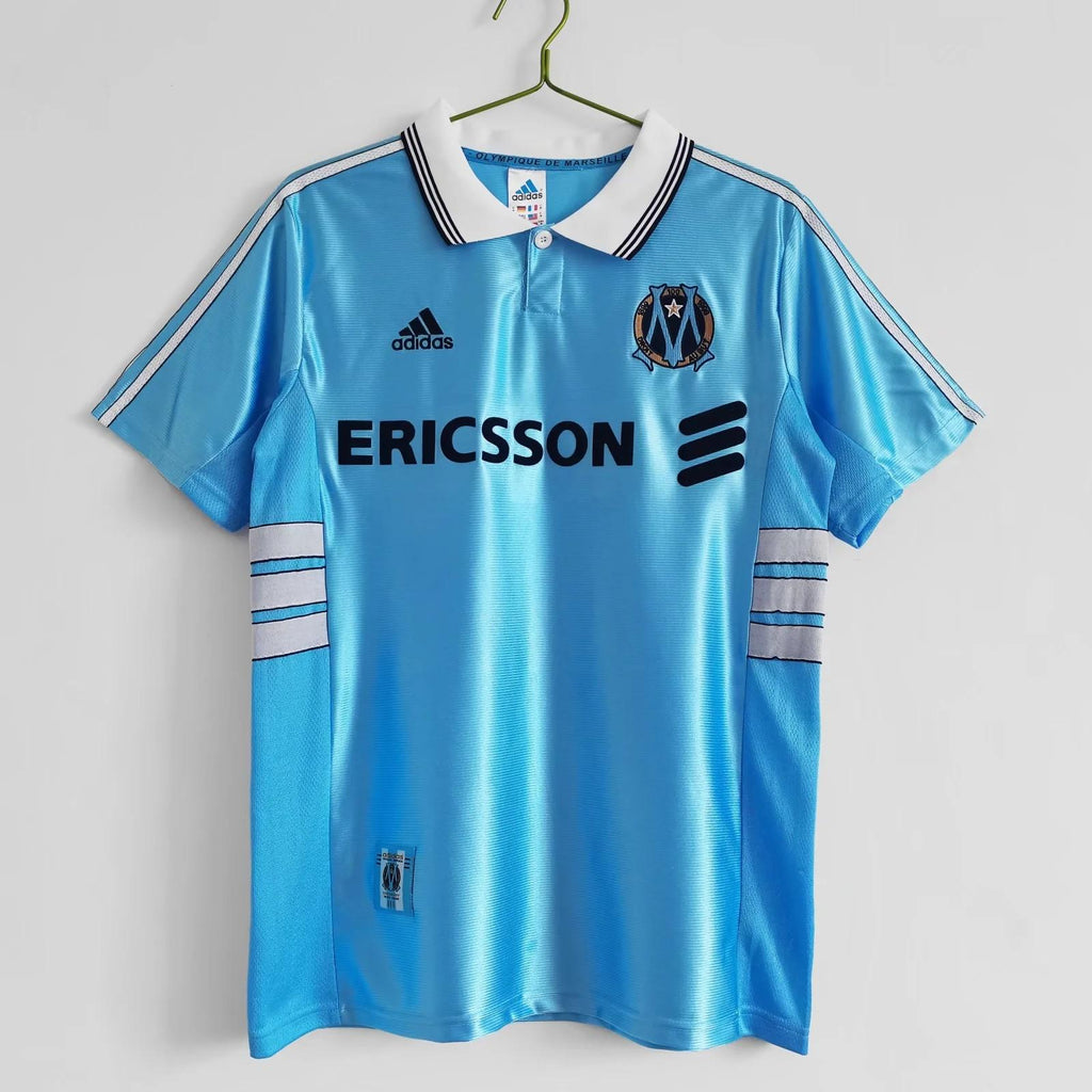 Sky blue away soccer jersey with ERICSSON sponsor, adidas logo, and Marseille crest