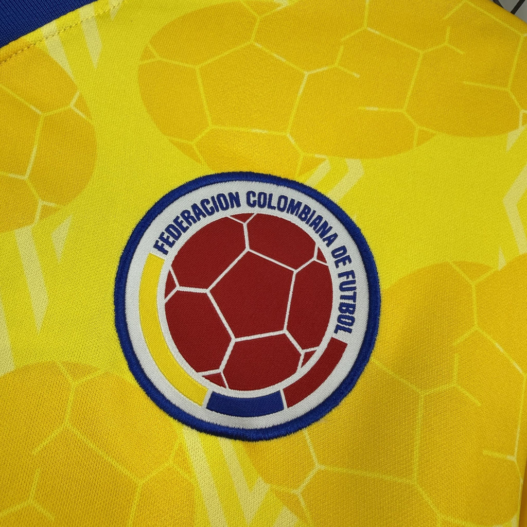 Colombia football crest patch on yellow jersey, blue border with red ball design.