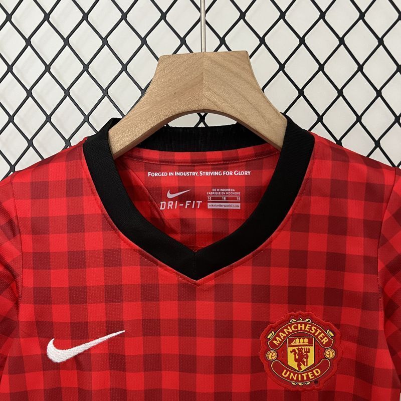 Kids Manchester United home jersey in red plaid with Nike swoosh and club crest