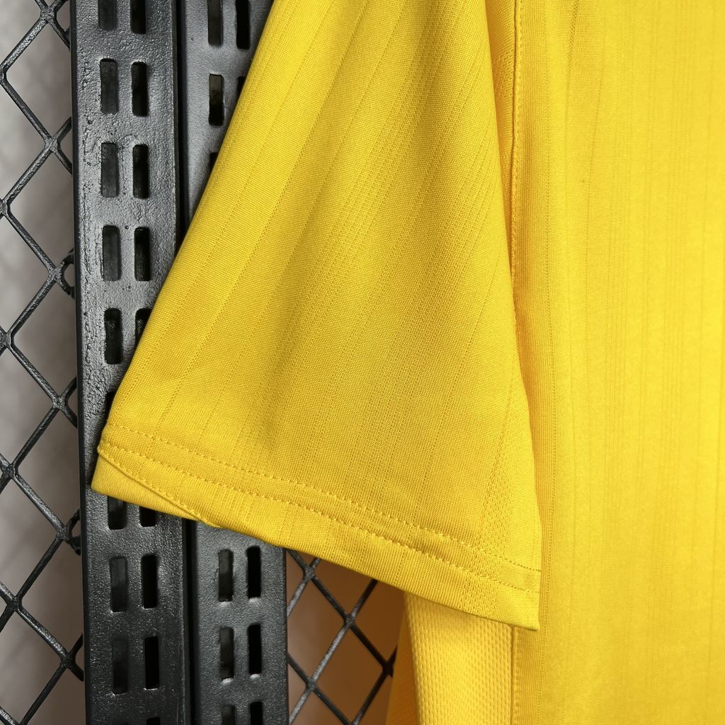 Yellow football jersey sleeve cuff and hem stitching with dark trim panel