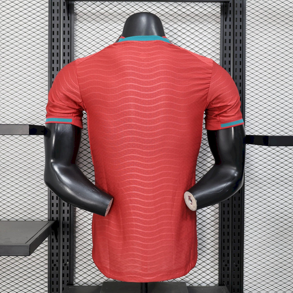 Red soccer jersey back view with wavy pattern and teal trim at collar