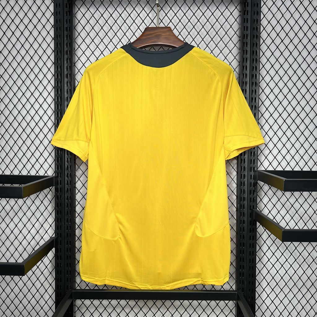 Yellow football jersey with dark crew neck trim, back view on hanger