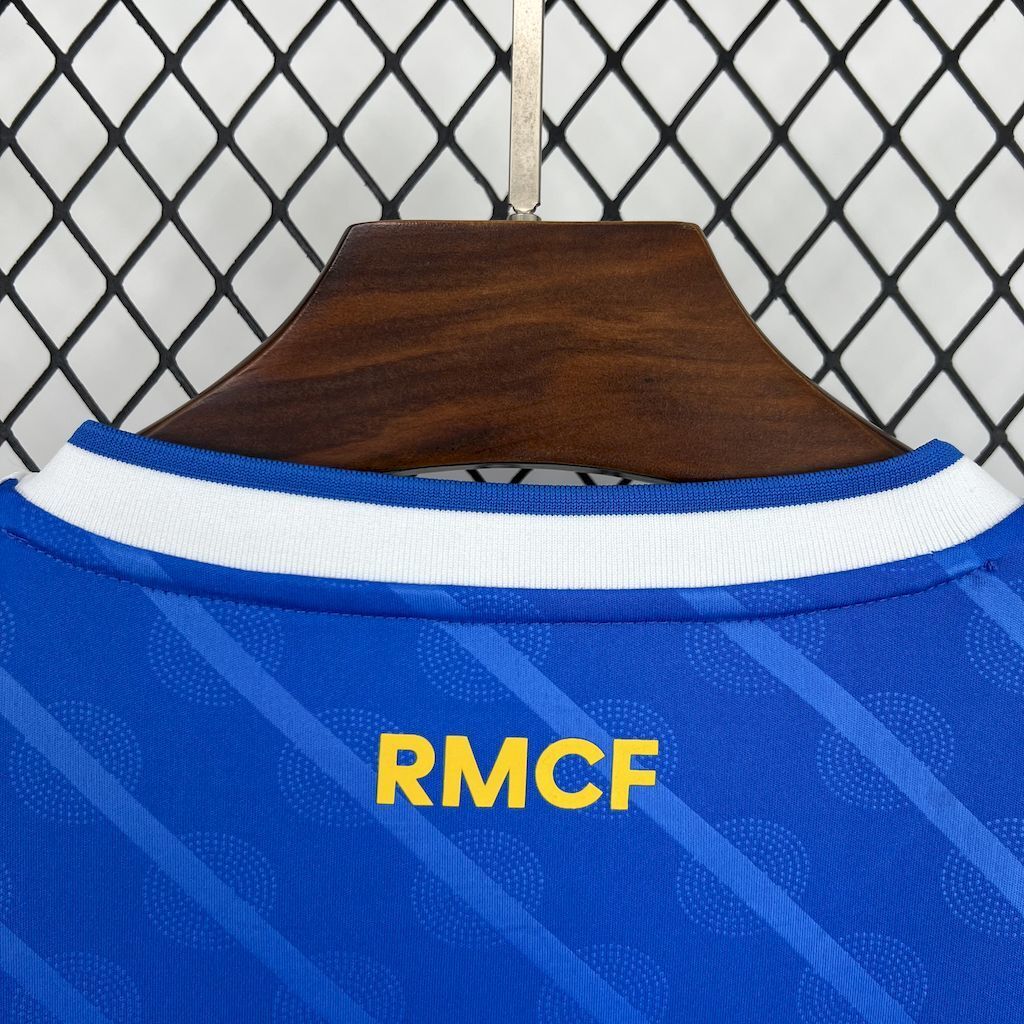 Real Madrid jersey back close-up with RMCF text near collar, blue with white trim